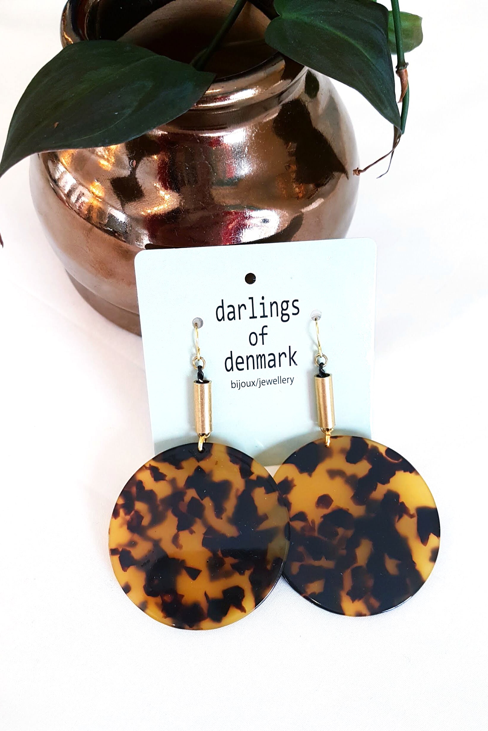 Flumme by Darlings of Denmark; dangle earrings; raw brass tubes with tortoise shell acrylic circle details; flat lay with packaging