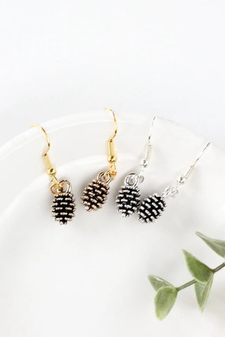 Pine cone earrings by Birch Jewellery; silver and gold; styled on a white ceramic dish