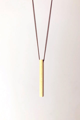 Beatrice necklace by Darlings of Denmark; mid-length chain; raw brass; vertical solid bar detail; close-up; flat lay
