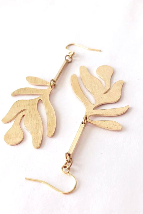 Fullie dangle earrings by Darlings of Denmark; smooth raw brass; abstract leaf hanging off slim brass bars; flat lay