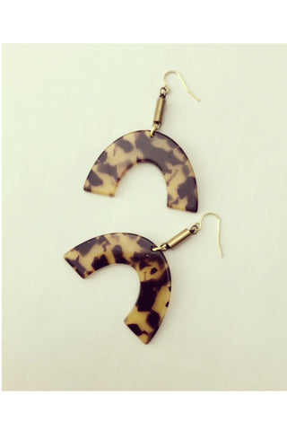 Vuttue dangle earring by Darlings of Denmark; tortoise shell acrylic arch hanging off raw brass tubes; flat lay